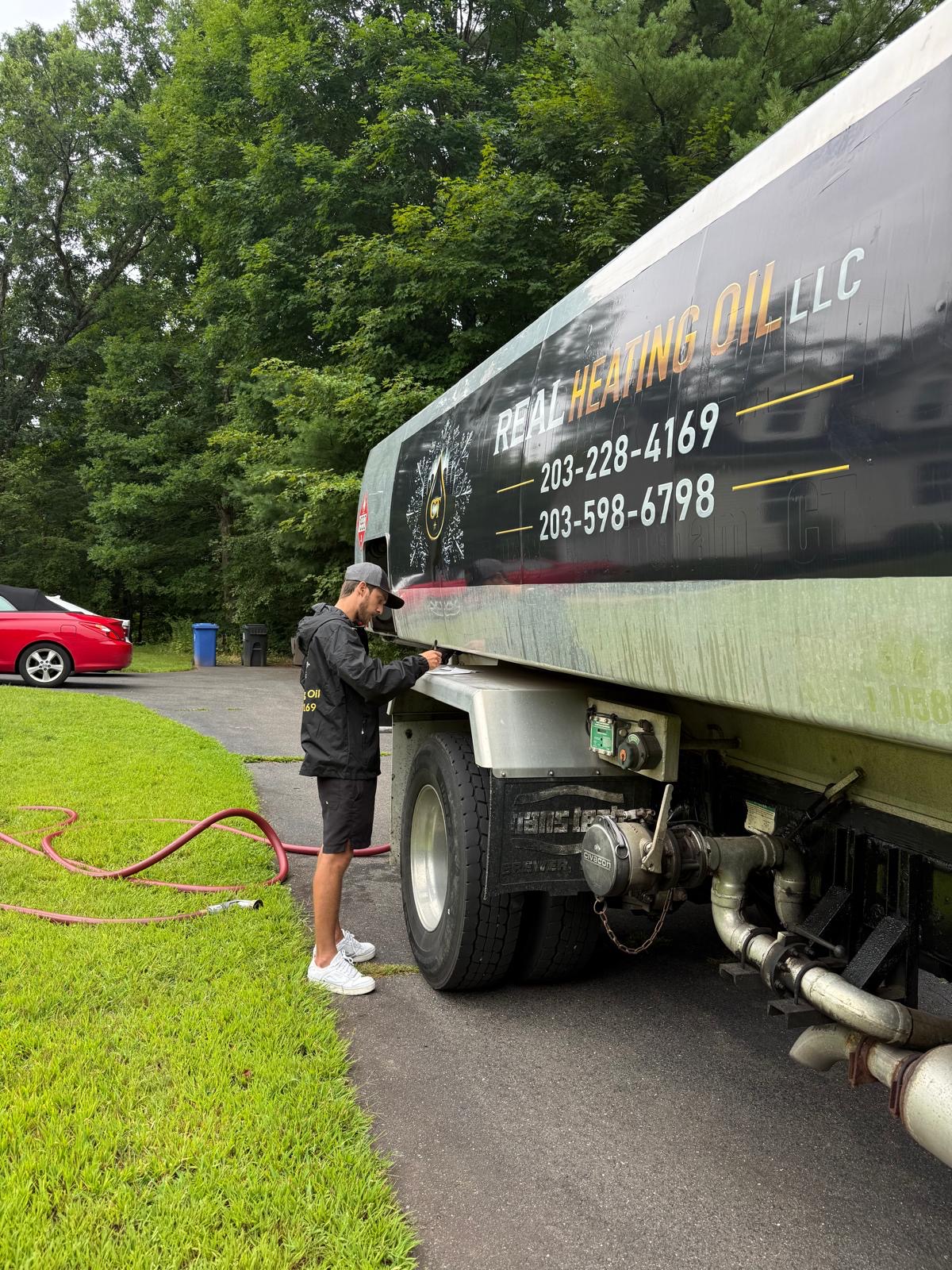 Real Heating Oil driver beside the company delivery truck
